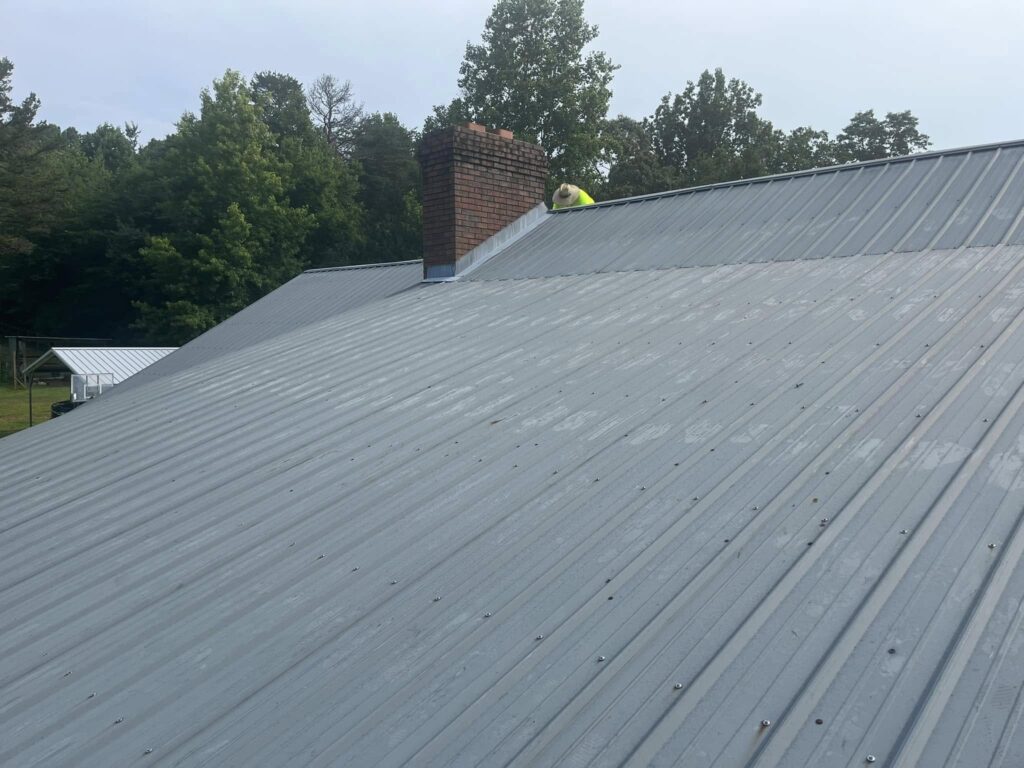 Roof Works crew member on a completed standing seam metal roof