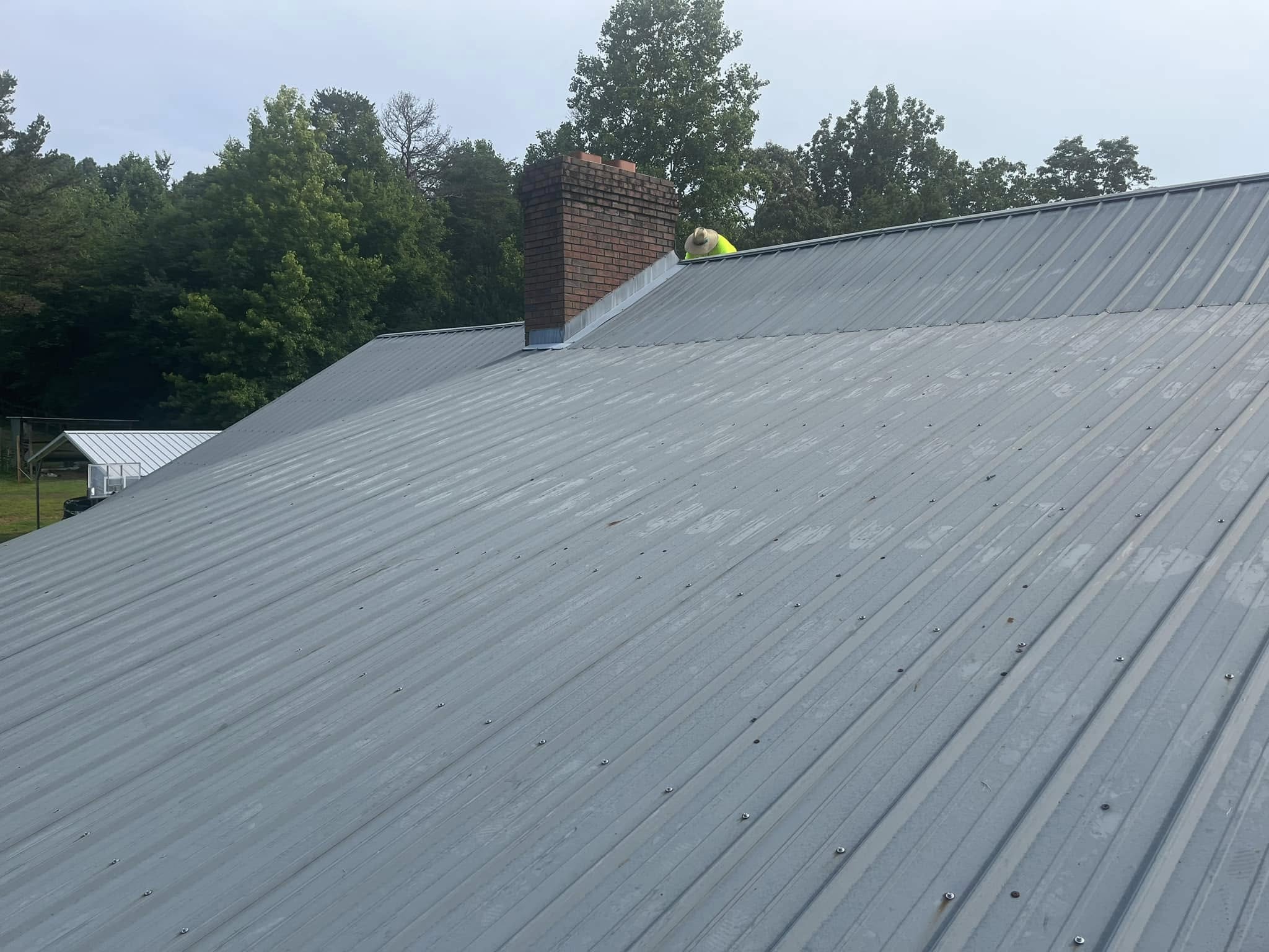 Roof Works crew member on a completed standing seam metal roof