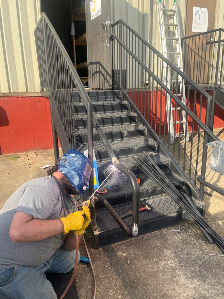 Roof Works welder repairing a commercial exterior staircase