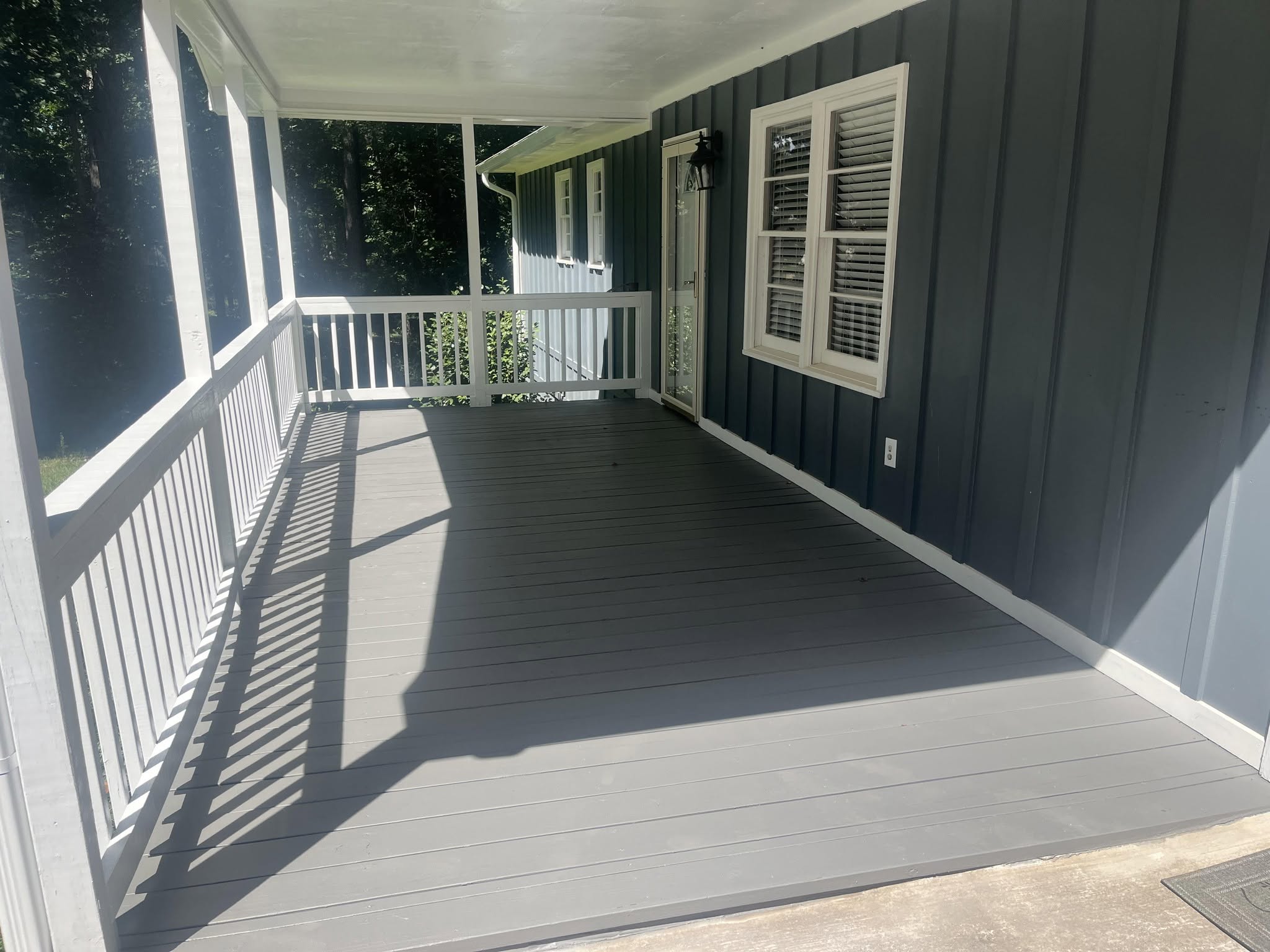Finished deck and porch build-out with a white rail, by Roof Works