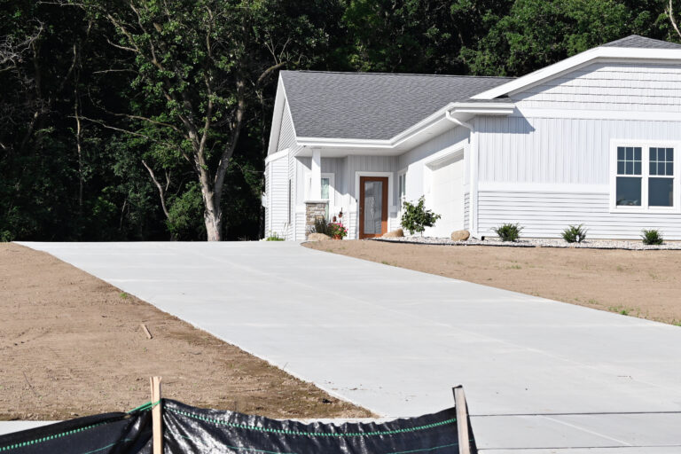 Newly poured concrete driveway running alongside a home