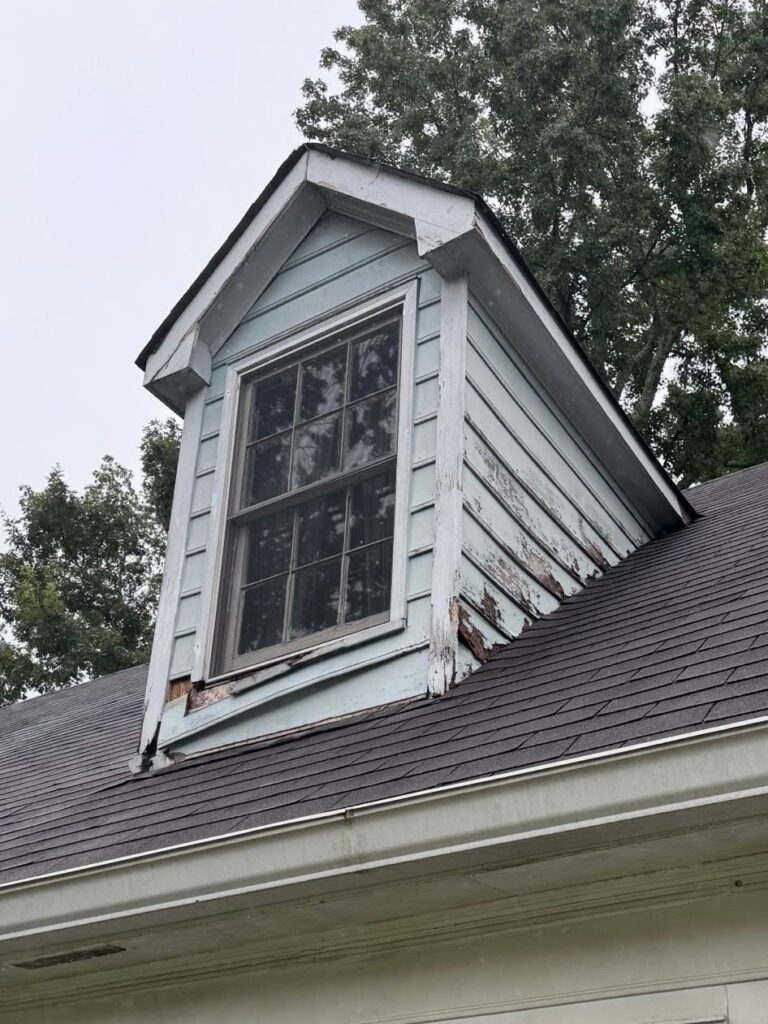 A worn dormer window before Roof Works replaced it