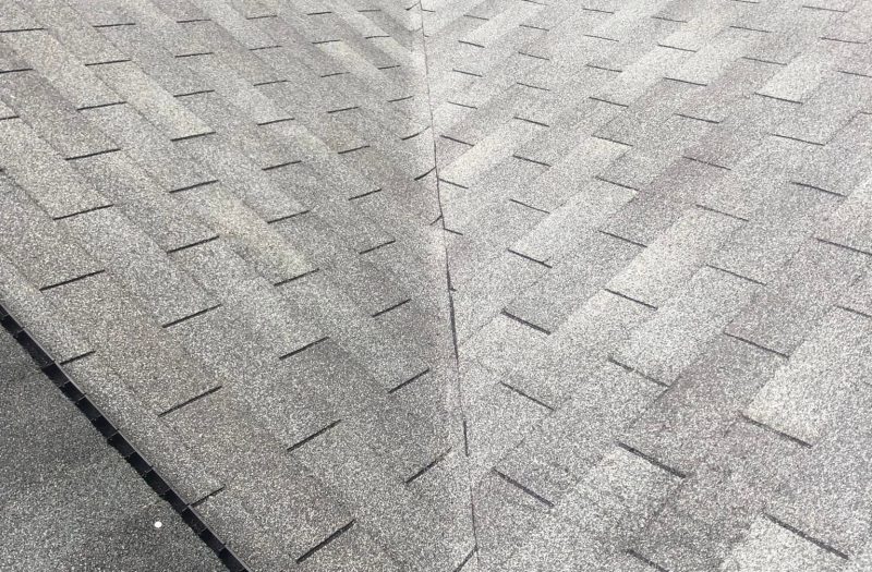 Close view of newly laid architectural shingles meeting at a roof valley