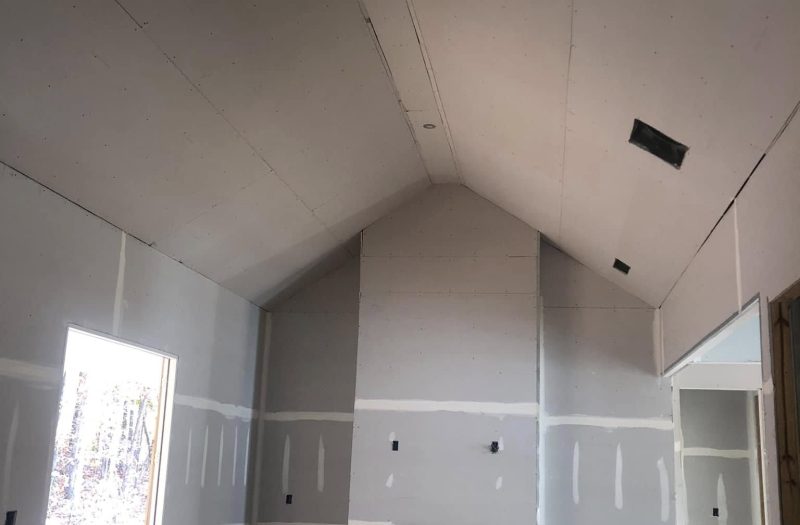 Room with newly hung and taped drywall and a vaulted ceiling