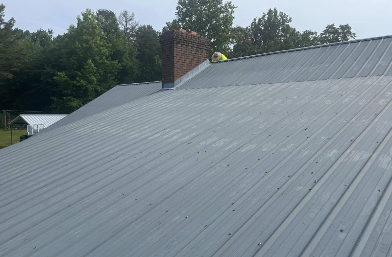 Roof Works crew member on a completed standing seam metal roof