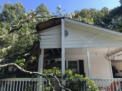 The porch roof of the same house crushed by the fallen tree