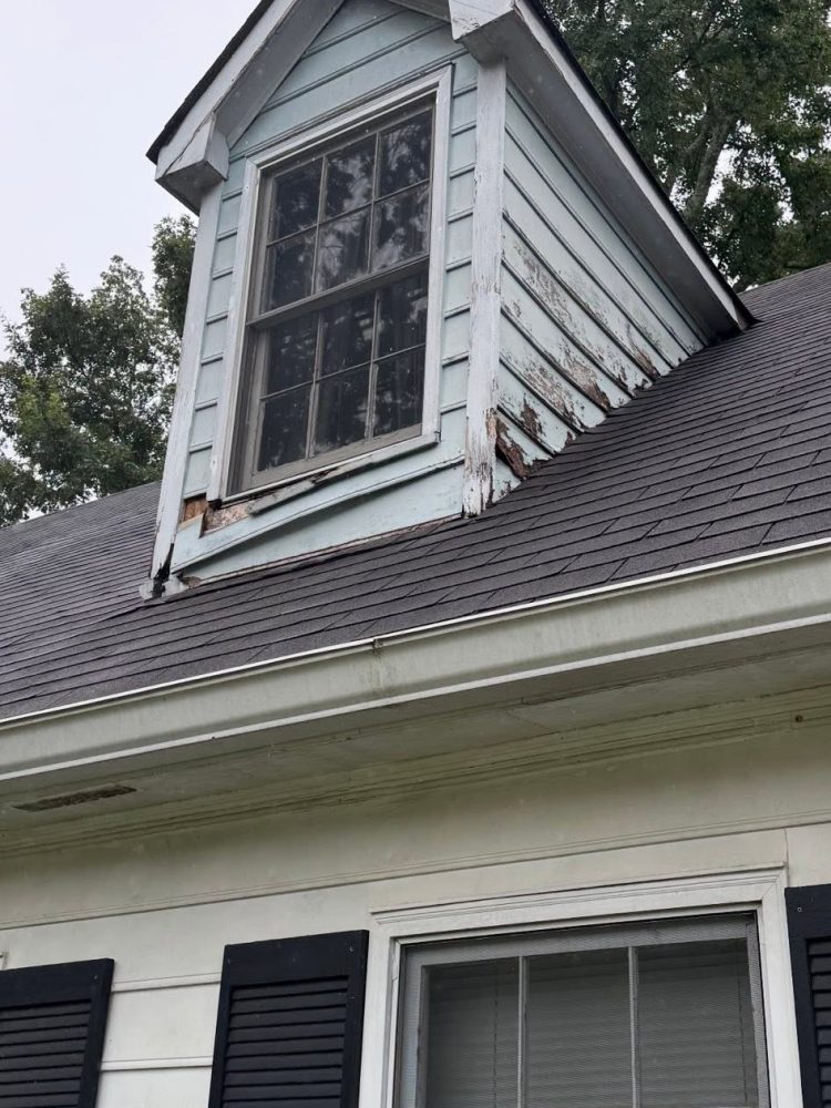 A worn dormer window and siding before Roof Works replaced them