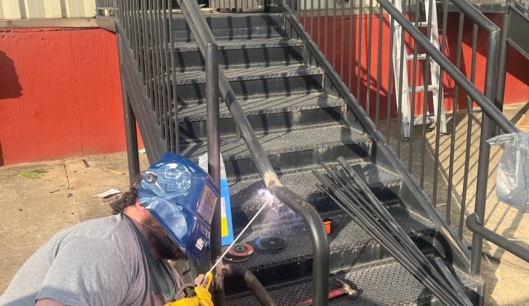 Roof Works welder repairing a commercial exterior staircase