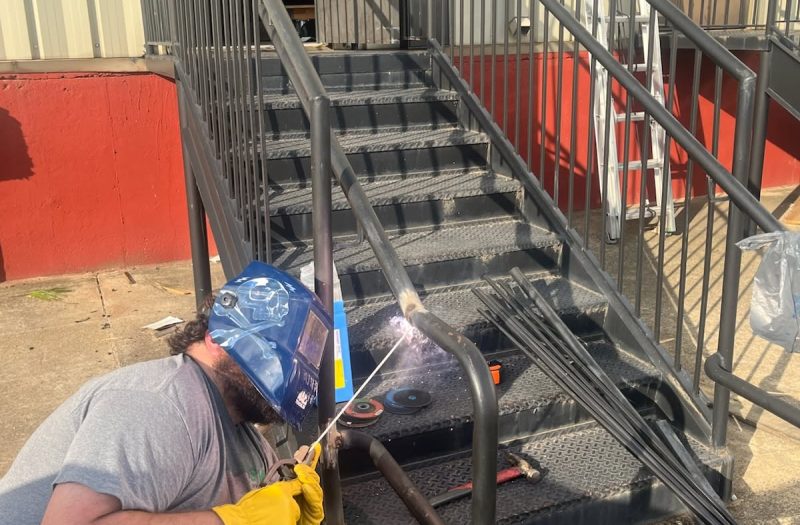 Roof Works welder repairing a commercial exterior staircase